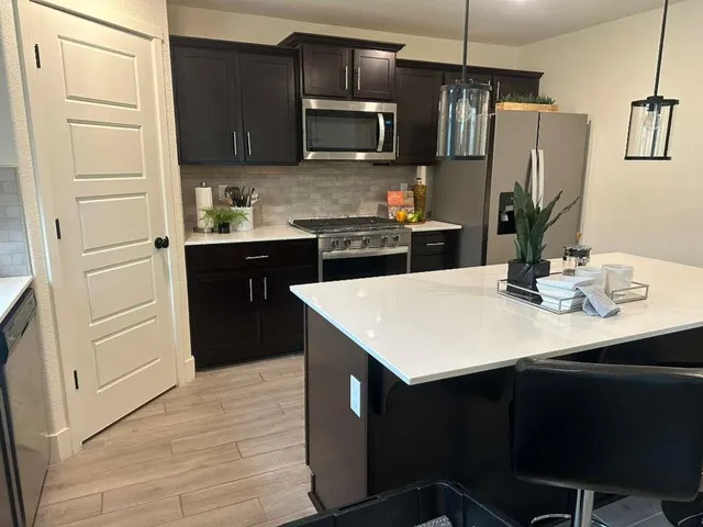 a kitchen with a sink a microwave a refrigerator and cabinets