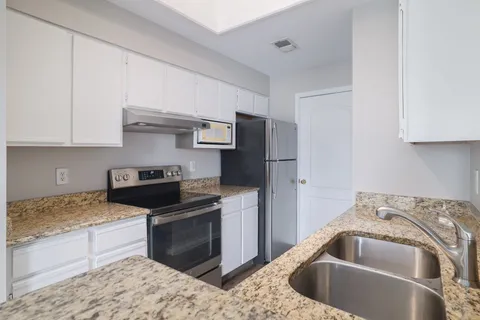 a kitchen with a stove sink and refrigerator