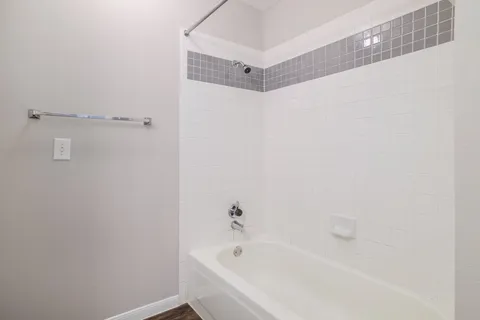 a white bath tub sitting next to a white sink and vanity