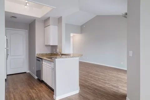 a view of kitchen with granite countertop cabinets and wooden floor