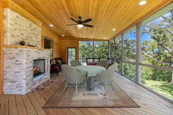 a dining room with furniture a fireplace and wooden floor