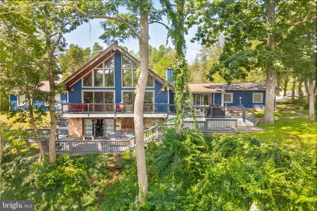 an aerial view of a house with a yard and lake view