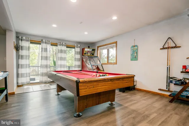 a living room with furniture a pool table and a fireplace