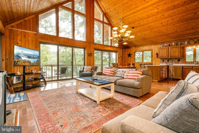 a kitchen with stainless steel appliances granite countertop a stove top oven a refrigerator and a dining table with wooden floor