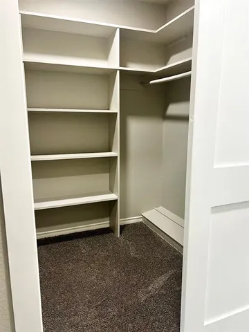 a bedroom with a bed a flat screen tv and a window