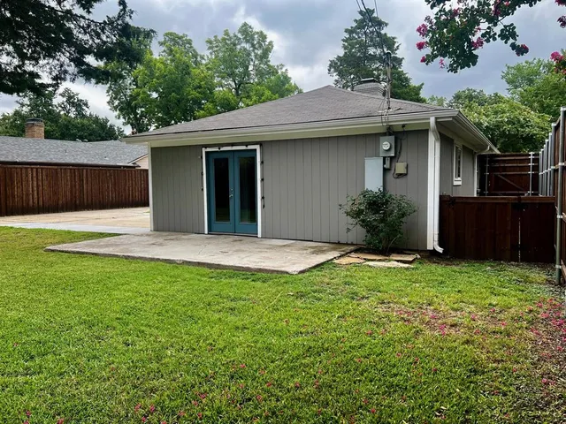 a view of a backyard with a garden and tree