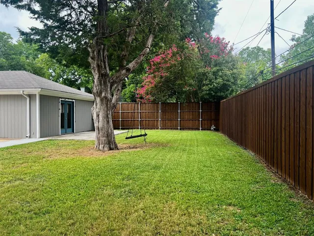 a view of a backyard with a garden and tree