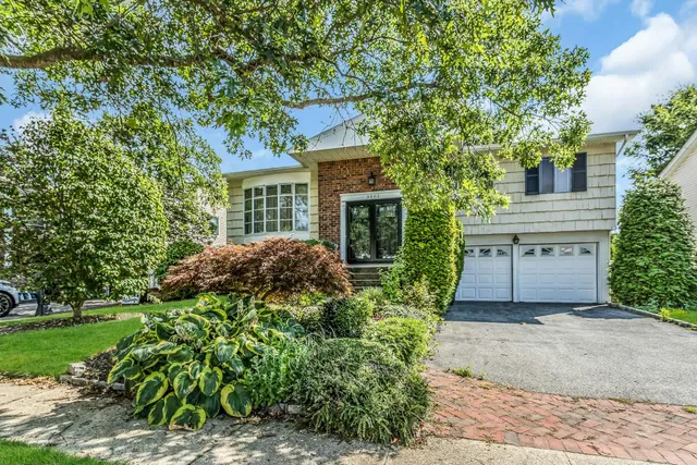 a view of a house with a small yard and potted plants