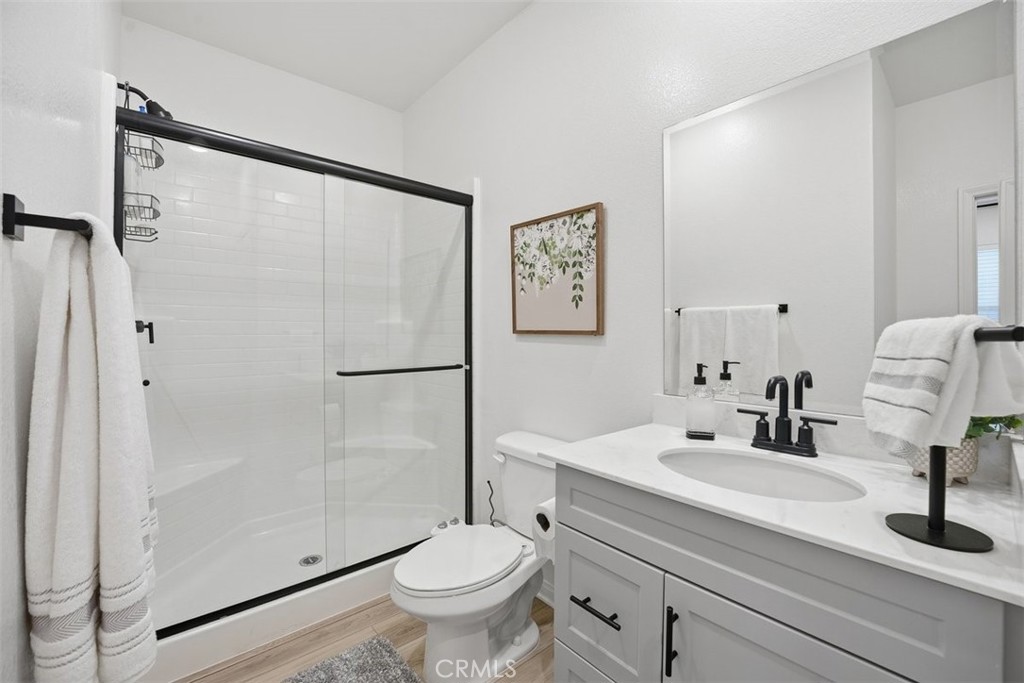 7608 Citrusmoon Court Riverside, CA 92507 - Photo 9 of 25 a bathroom with a sink a mirror a toilet and shower