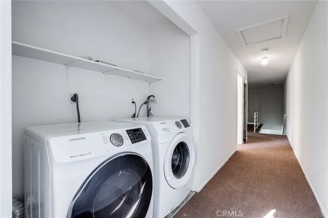 a view of washer and dryer with kitchen in the background