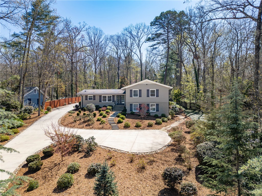 A split-level home with a sprawling driveway awaits, surrounded by nature's embrace.
