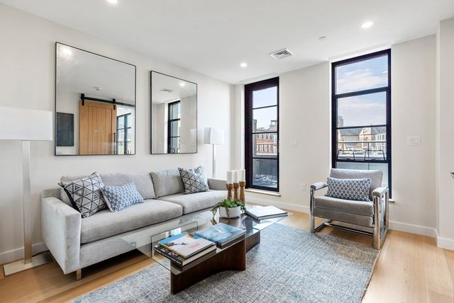 a living room with furniture and a potted plant with wooden floor