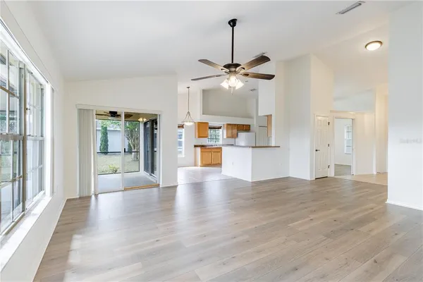 a room view with wooden floor and a kitchen