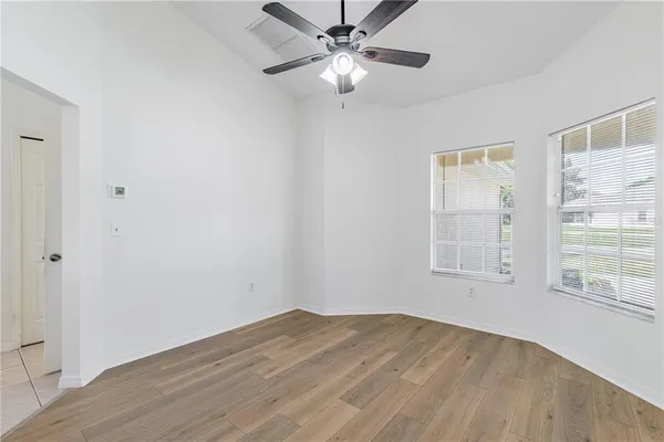 a view of a room with wooden floor and a ceiling fan