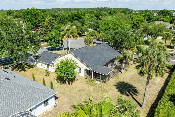 an aerial view of residential houses with outdoor space and trees