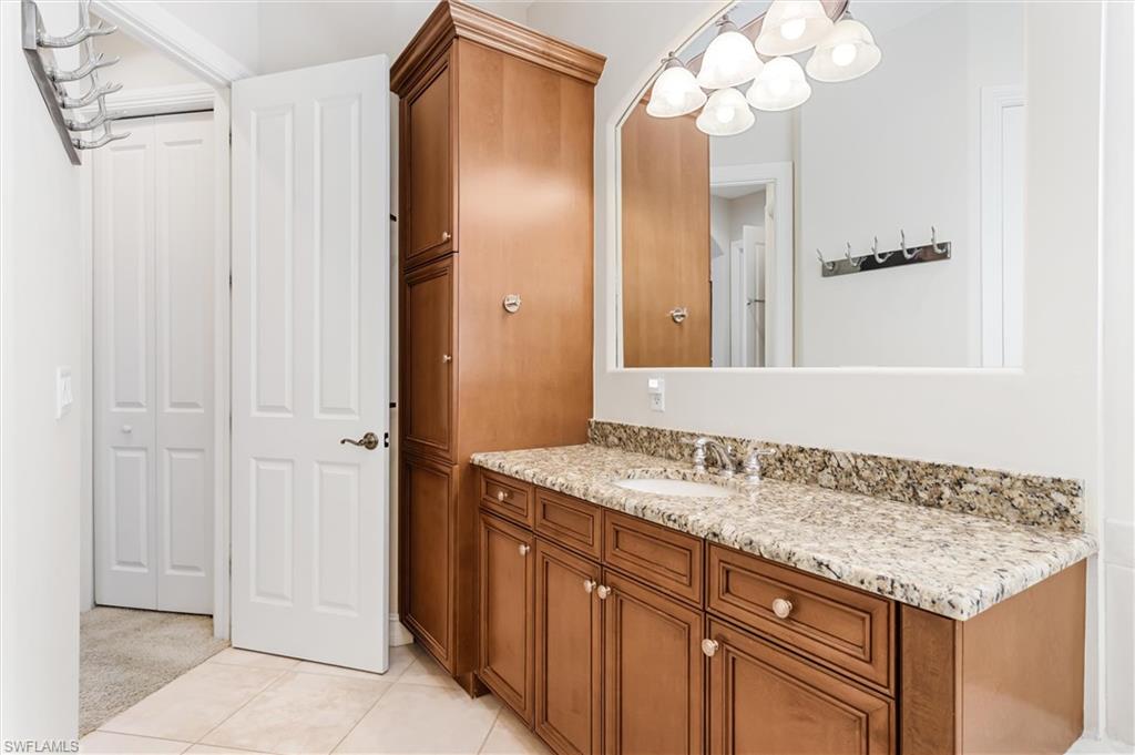 7794 Ashton Road Naples, FL 34113 - Photo 16 of 34 a bathroom with a granite countertop sink and a mirror