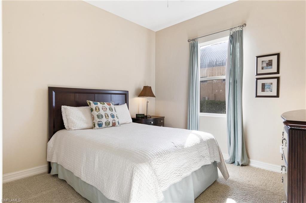 7794 Ashton Road Naples, FL 34113 - Photo 18 of 34 a large bed sitting in a bedroom next to a window
