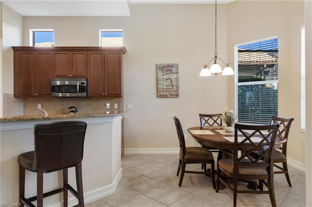 7794 Ashton Road Naples, FL 34113 - Photo 5 of 34 a view of a kitchen with dining area cabinets and a wooden floor