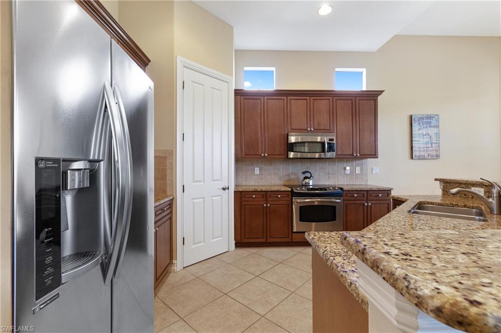 7794 Ashton Road Naples, FL 34113 - Photo 6 of 34 a kitchen with stainless steel appliances granite countertop a refrigerator stove and oven