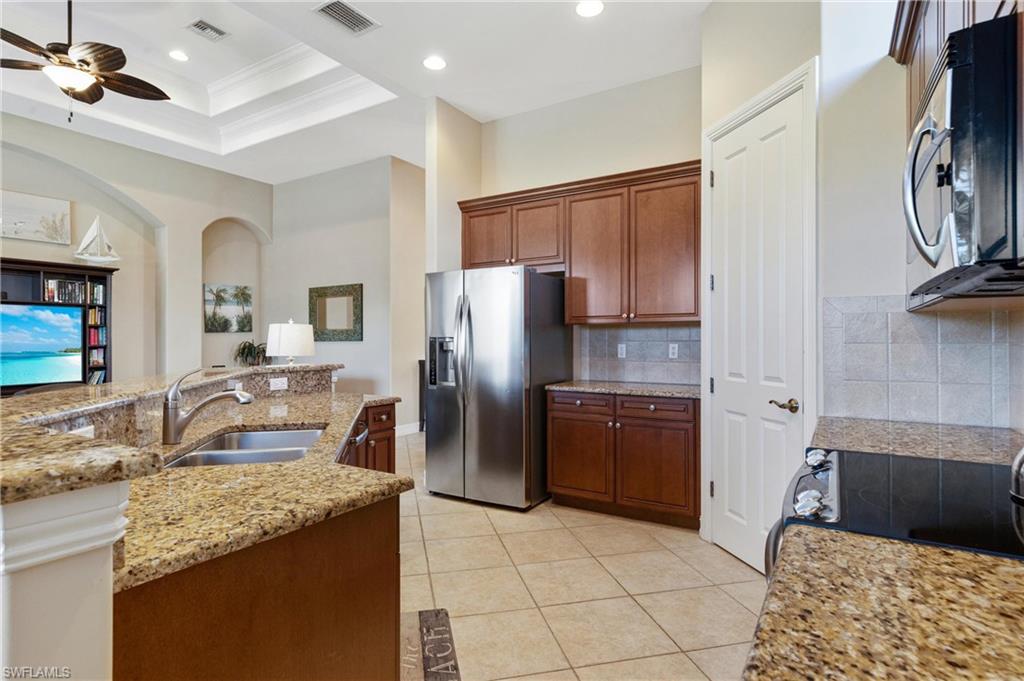 7794 Ashton Road Naples, FL 34113 - Photo 7 of 34 a kitchen with a refrigerator sink and stove