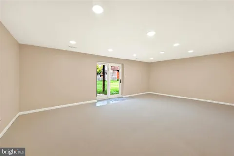 an empty room with a window and a projector screen