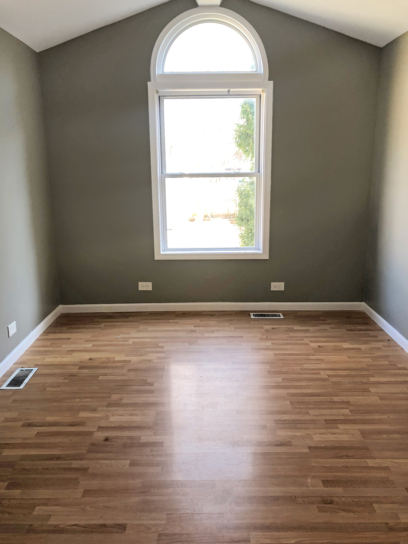 Undisclosed Address Round Lake Beach, IL 60073 - Photo 5 of 8 an empty room with wooden floor and windows