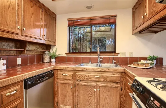 a kitchen with stainless steel appliances granite countertop a sink stove and cabinets