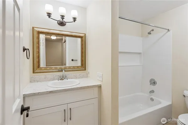 a bathroom with a bathtub a sink a mirror and a shower