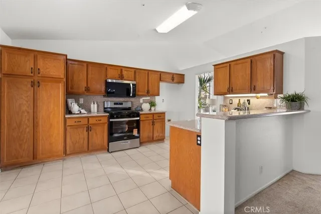 a kitchen with granite countertop a refrigerator stove top oven and sink