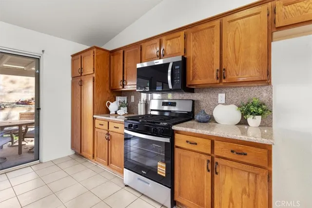 a kitchen with stainless steel appliances granite countertop a stove a sink dishwasher and a refrigerator