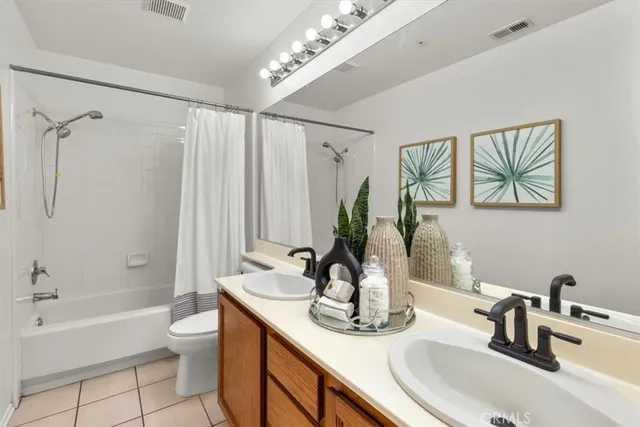 a bathroom with a granite countertop sink a toilet a mirror and shower
