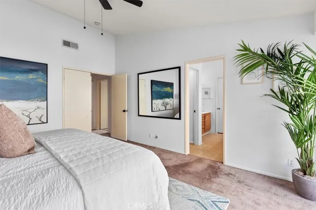 a bedroom with a large bed and a potted plant