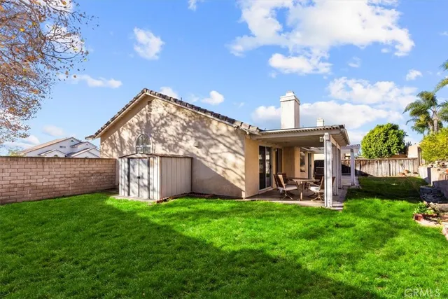 a view of a house with a yard and table in front of it