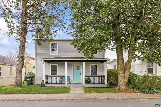 a front view of a house with a garden and tree