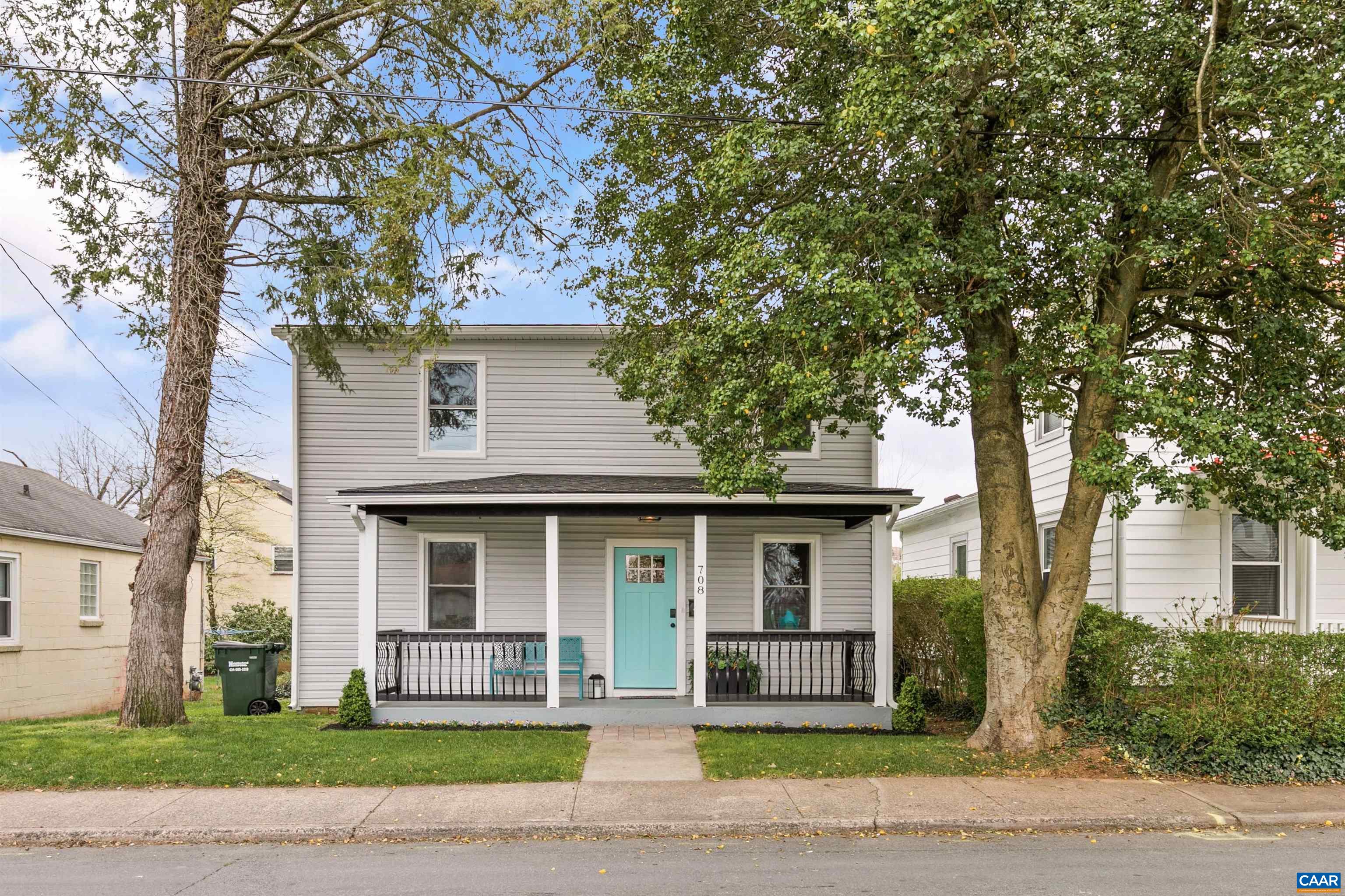 a front view of a house with a garden and tree