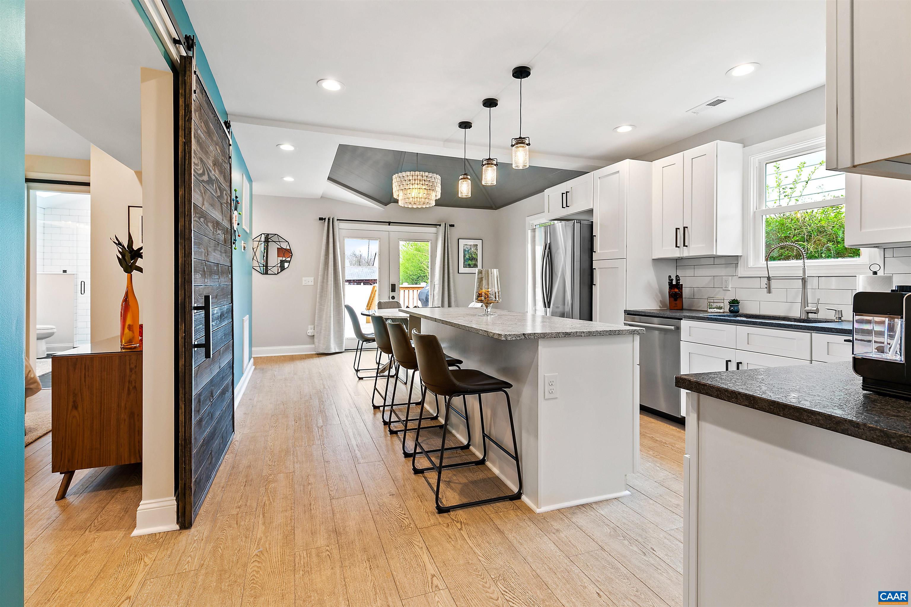 708 West Street Charlottesville, VA 22903 - Photo 9 of 34 a kitchen with stainless steel appliances kitchen island granite countertop a refrigerator a sink a stove and white cabinets with wooden floor