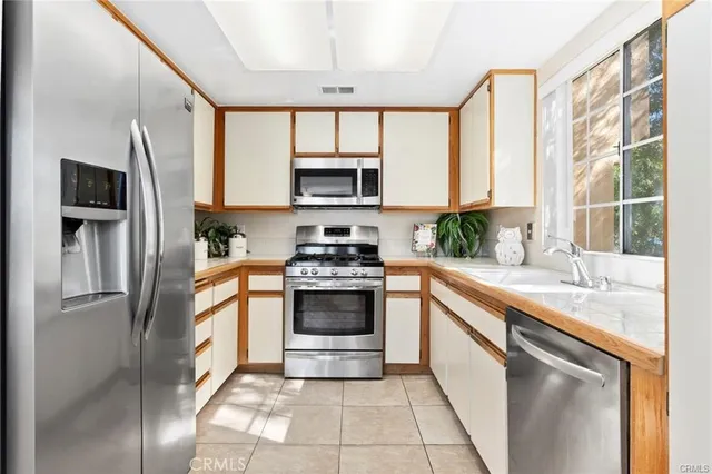 a kitchen with a sink and chairs