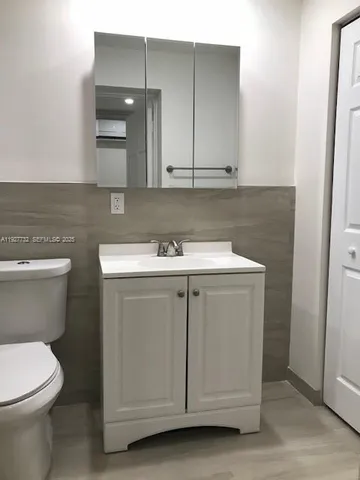 a utility room with a sink a toilet and cabinets