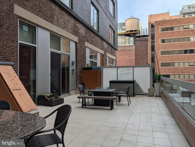 a backyard of a house with barbeque oven table and chairs
