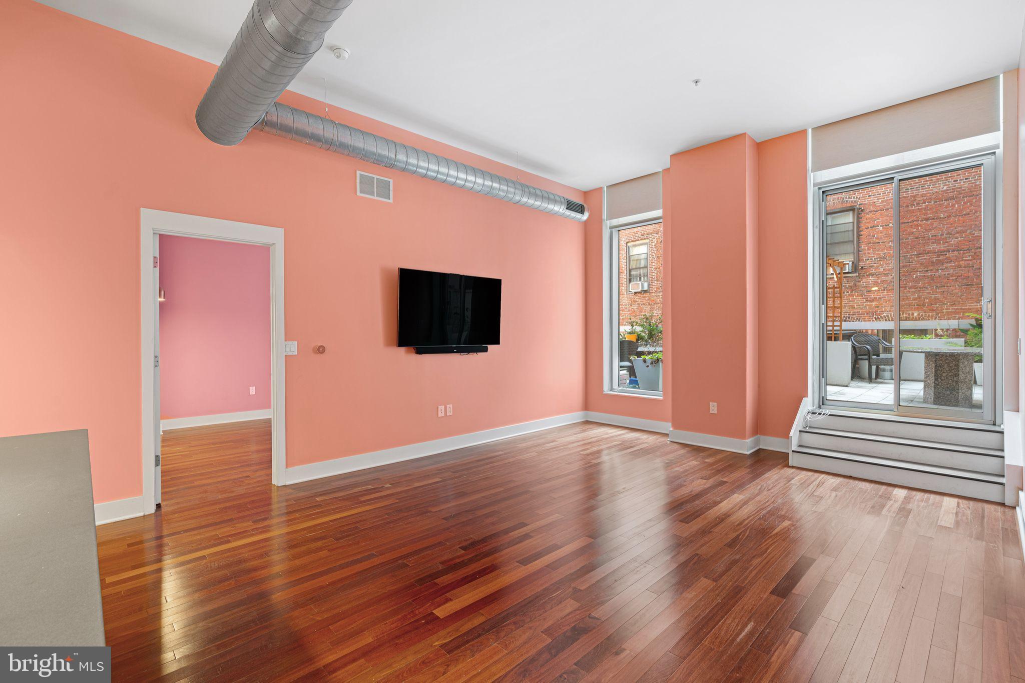 1101 Locust Street, Unit 4L Philadelphia, PA 19107 - Photo 11 of 25 a view of an empty room with wooden floor and a window