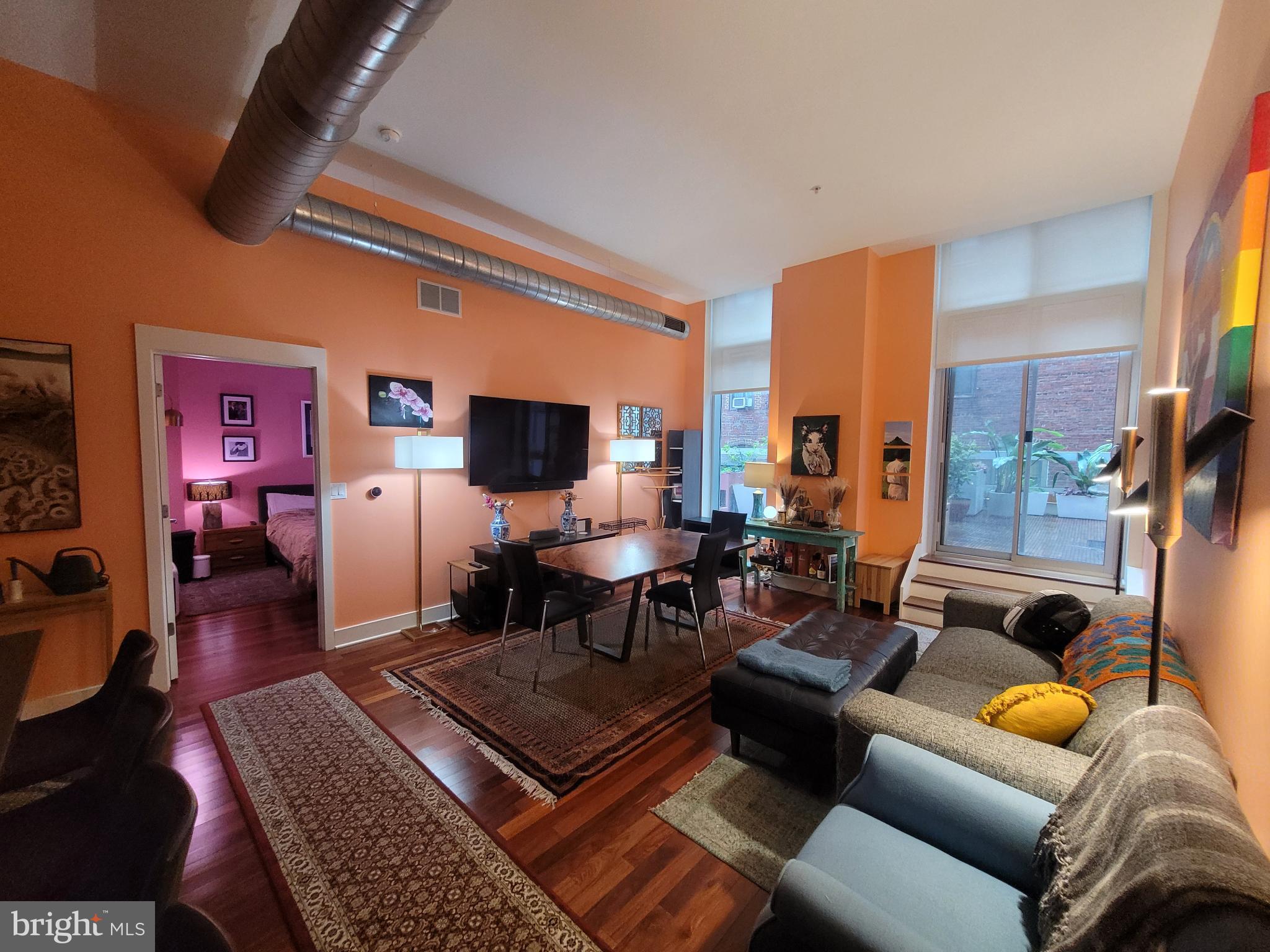 1101 Locust Street, Unit 4L Philadelphia, PA 19107 - Photo 12 of 25 a living room with furniture a flat screen tv and kitchen view