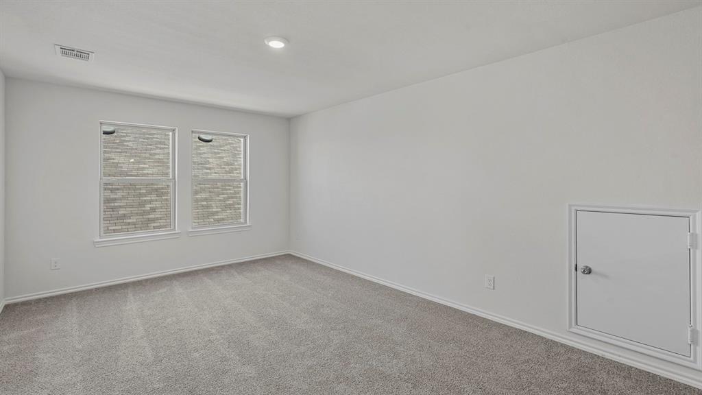 1627 Mantle Road Crandall, TX 75114 - Photo 13 of 40 Carpeted room with two windows, white walls, and a built-in access panel