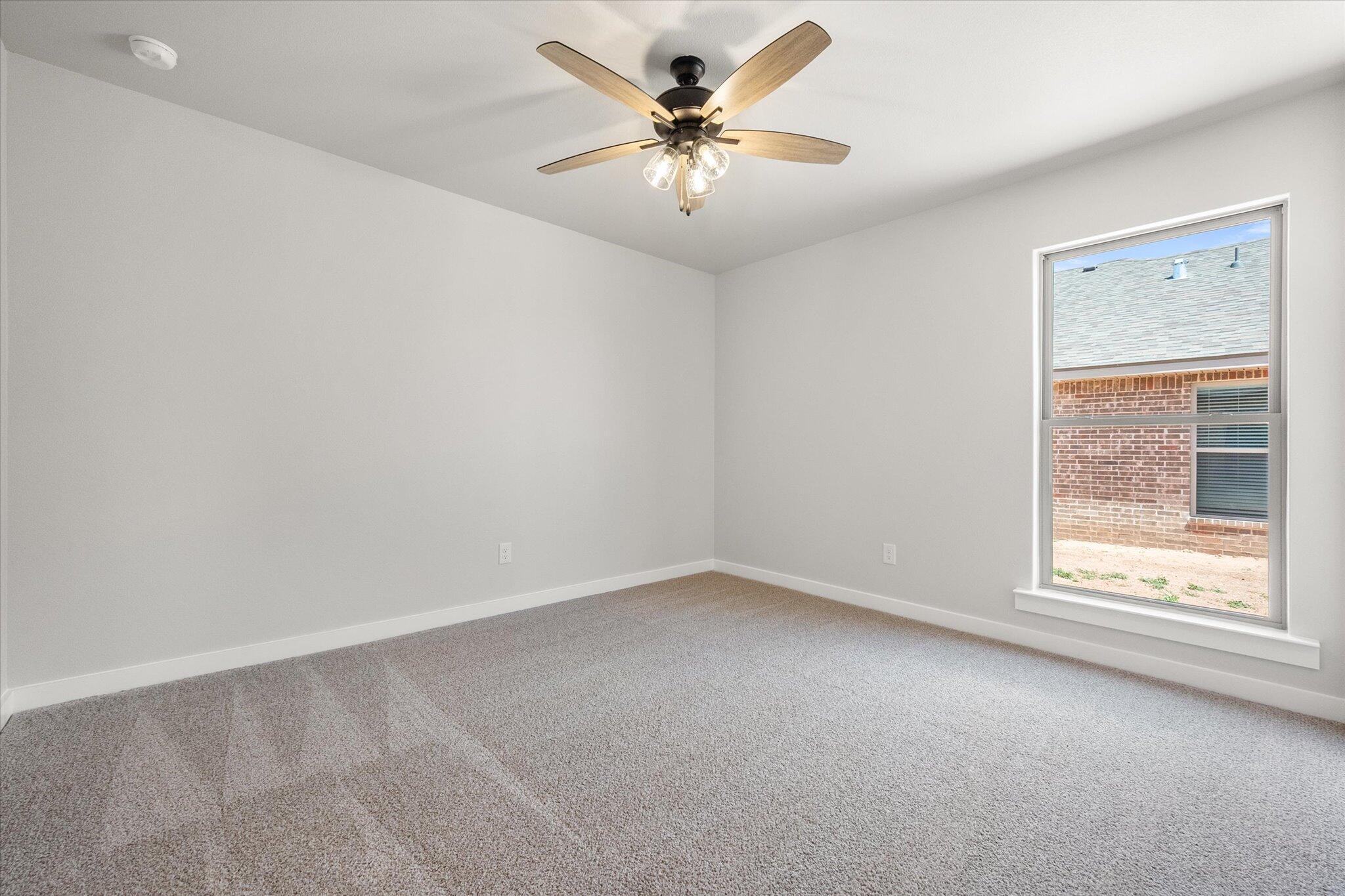 7436 29th Street Lubbock, TX 79407 - Photo 19 of 22 an empty room with windows and fan