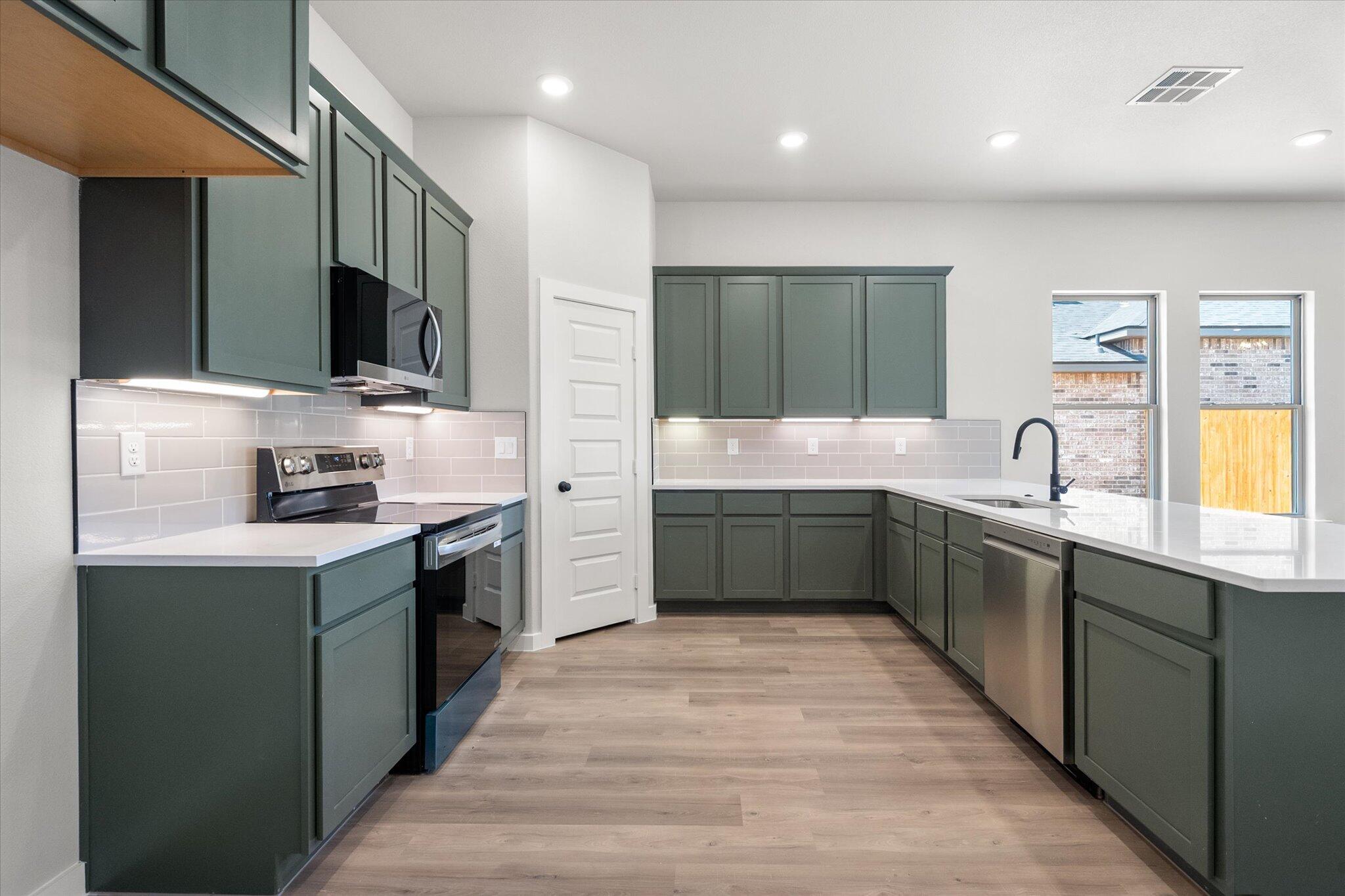 7436 29th Street Lubbock, TX 79407 - Photo 4 of 22 a kitchen with stainless steel appliances granite countertop a sink and cabinets