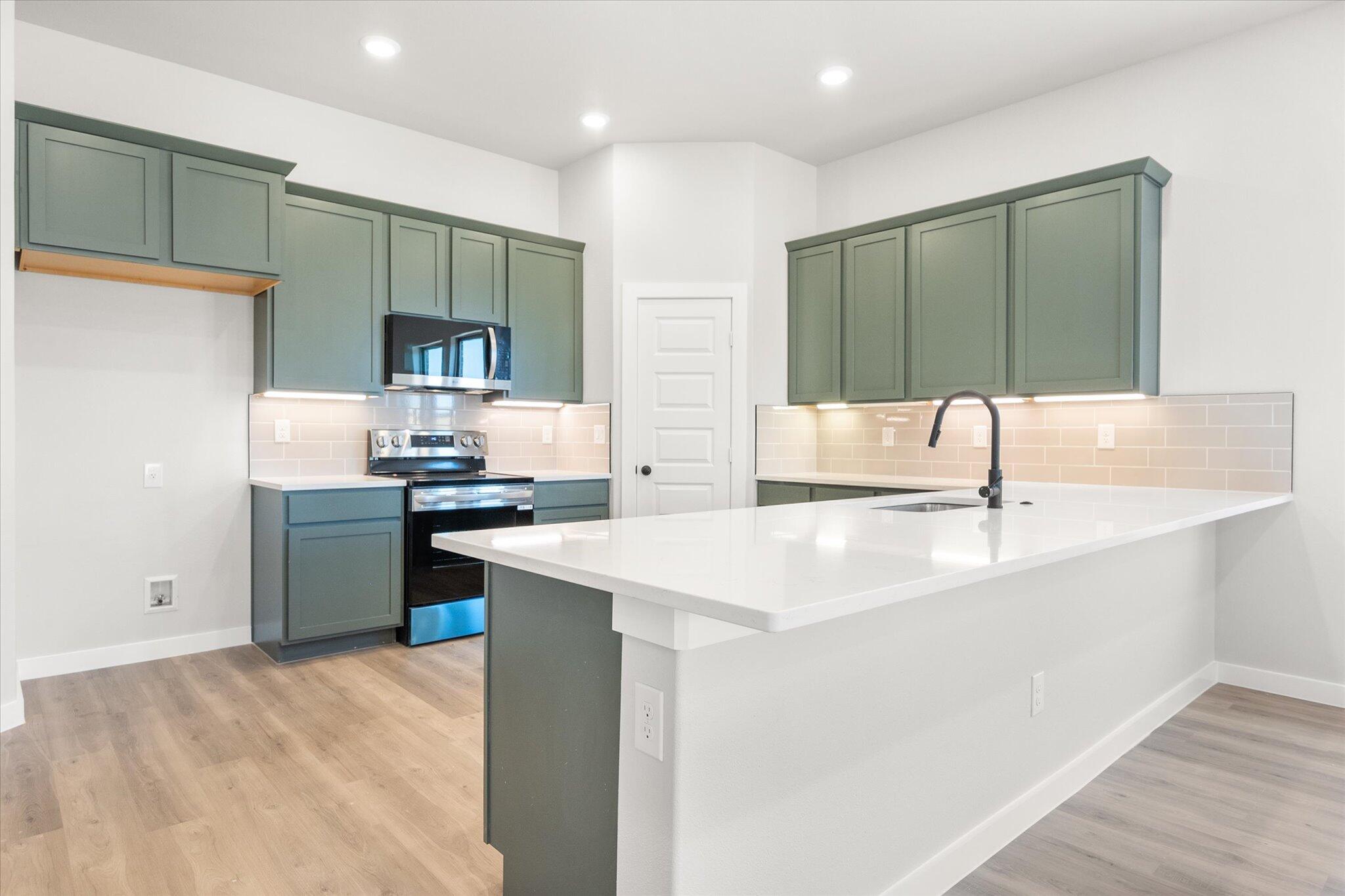 7436 29th Street Lubbock, TX 79407 - Photo 5 of 22 a kitchen with stainless steel appliances kitchen island a sink stove and refrigerator