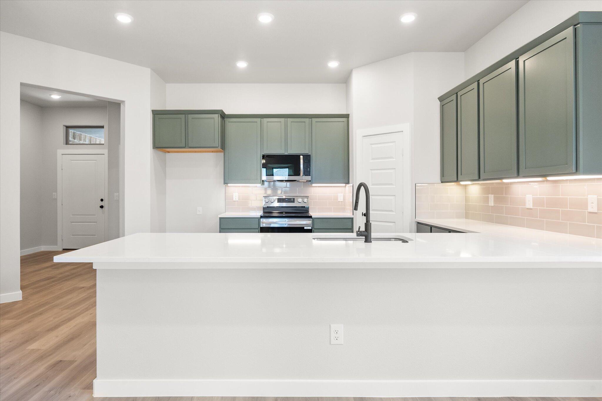 7436 29th Street Lubbock, TX 79407 - Photo 6 of 22 a large white kitchen with kitchen island a sink stainless steel appliances and cabinets