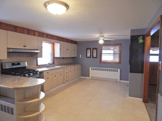 109 South Stott Street, Unit 2 Genoa, IL 60135 - Photo 2 of 14 a kitchen with stainless steel appliances granite countertop a stove a sink and a refrigerator