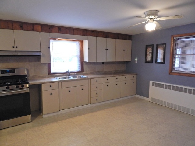 109 South Stott Street, Unit 2 Genoa, IL 60135 - Photo 4 of 14 a large kitchen with cabinets appliances a sink and a window