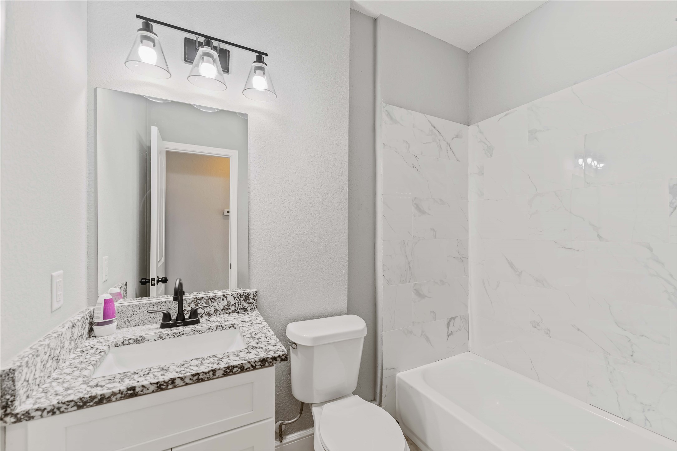 4651 Mallow Street, Unit AB Houston, TX 77051 - Photo 13 of 20 a bathroom with a granite countertop sink toilet and shower