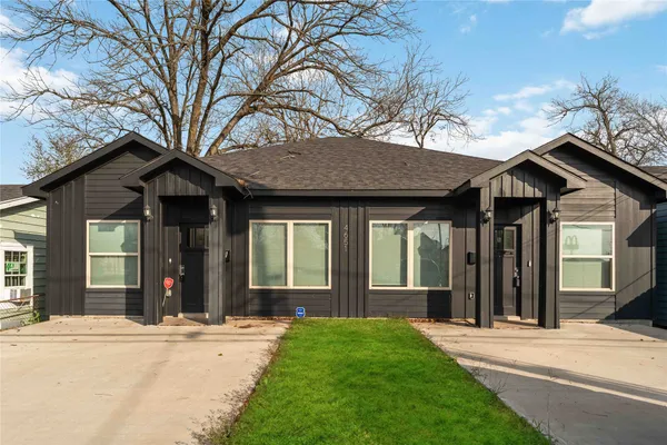 front view of a brick house with a yard